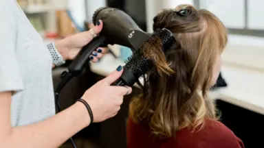 person blow drying clients hair
