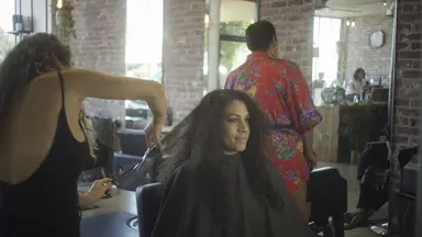 female stylist cutting hair in salon
