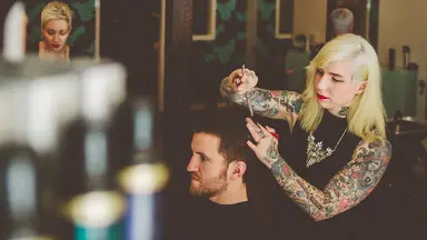 Woman cutting a man's hair. 