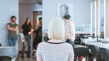 woman with platinum hair sitting in a salon 