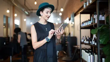 Person in salon holding tablet