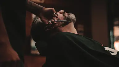man in barbershop getting beard trimmed