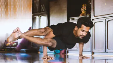 Man practicing yoga through virtual Fitness at home