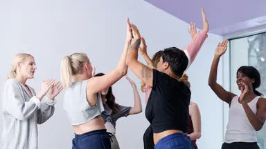 People high-fiving in a studio.