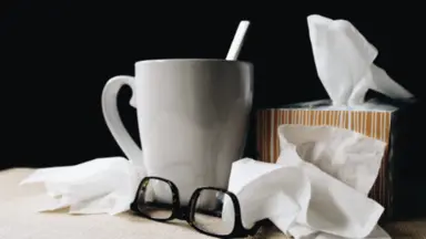 tea cup glasses and tissues on desk