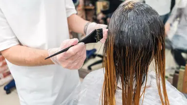 woman getting hair colored in salon