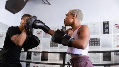 man and woman boxing in gym
