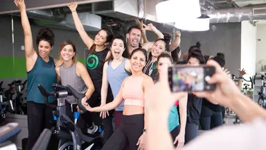 A group of people pose for a photo in a spin studio.