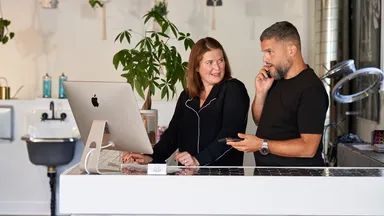 man and woman at front desk of salon spa