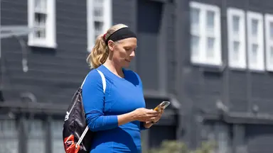 Woman in blue top looking at her phone