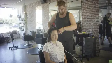 man cutting female client hair in salon