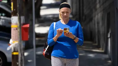 woman walking while on her phone