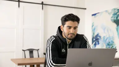 man sitting at desk on laptop