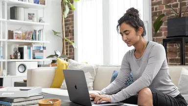 woman on couch on laptop at home