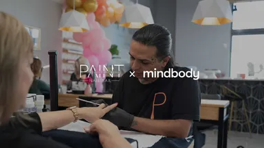 nail tech filing a woman's nails in a salon 