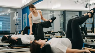 Clients and an instructor during a Pilates class