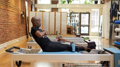 A man using a Pilates reformer