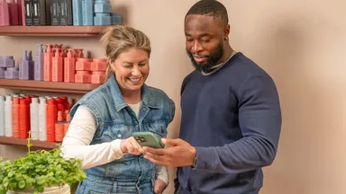 Two people using a phone 