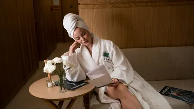 A woman sitting in a robe at the spa