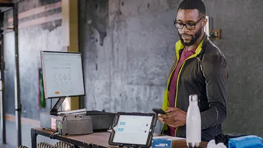 Man running front desk at fitness business