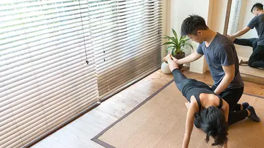 Person stretching with trainer