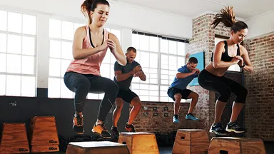 People doing box jumps in gym