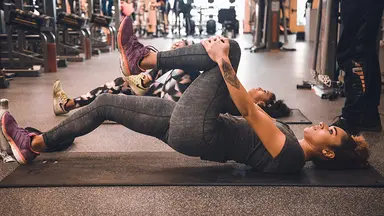 Two women exercising at a fitness studio with a trainer