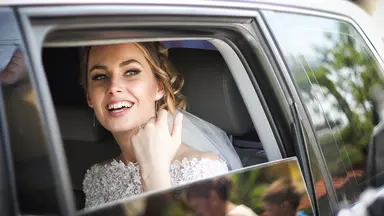 Bride smiling in car window