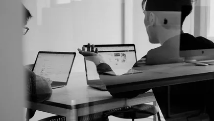 man and woman looking at computer