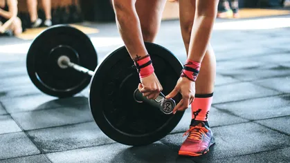 woman adjusting weight on barbell