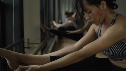 woman in striped sports attire doing barre