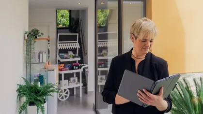 Spa business owner in black shirt looking at financial reports in a black binder