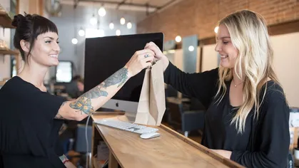 An employee checking a client out at a salon.
