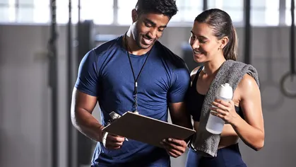 Instructor showing information to a female member at a gym