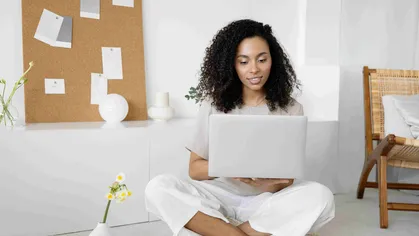 Gym owner in white pants looking at laptop