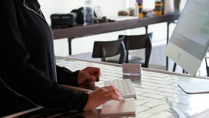 A woman using a computer at the front desk