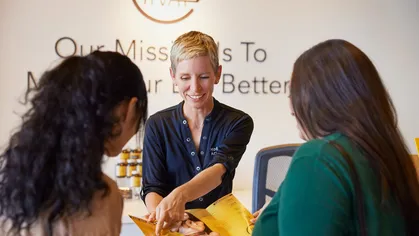 2 customers speaking to a receptionist at an acupuncture business