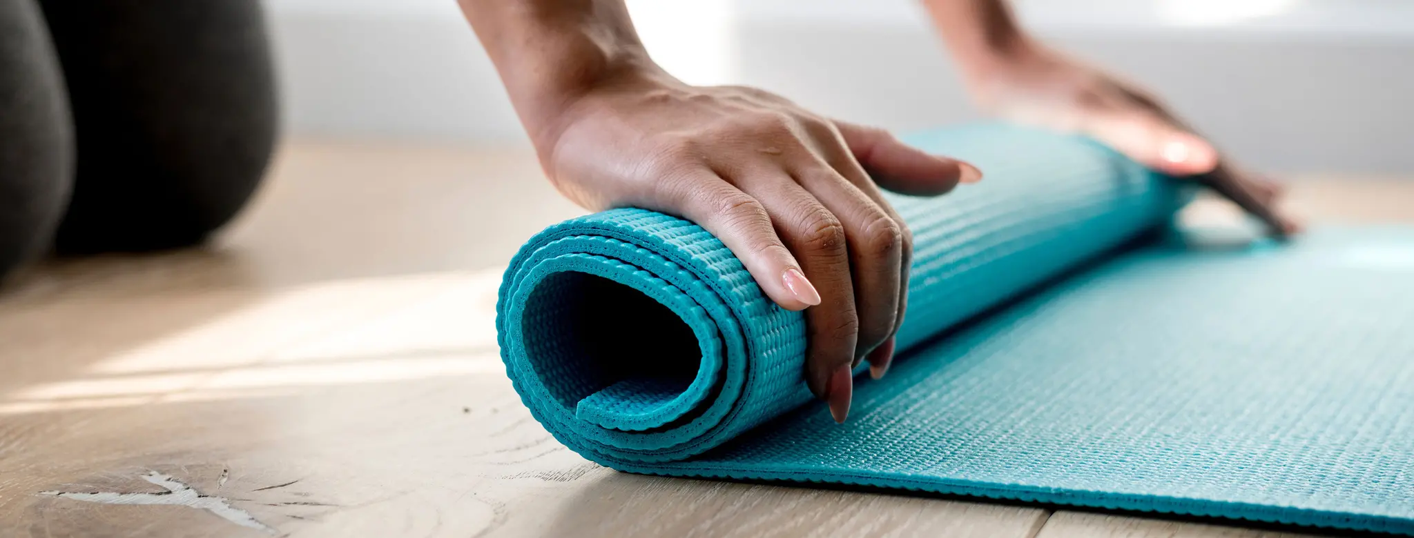 Woman rolling out a yoga mat