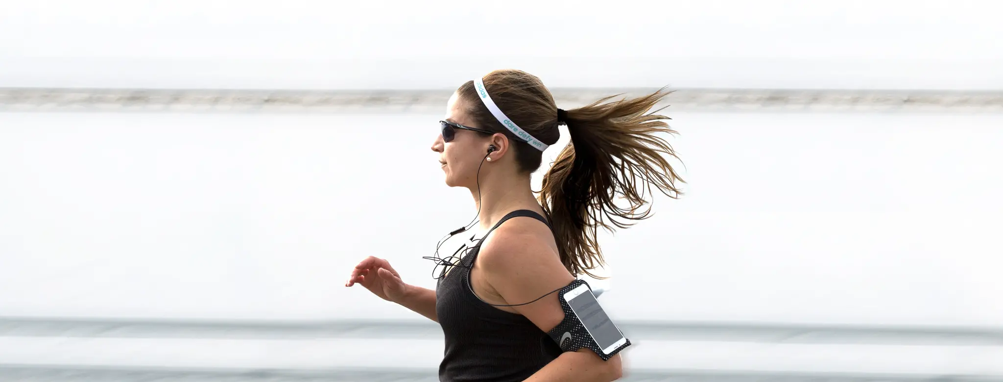 Woman running in sunglasses wearing a fitness tracker