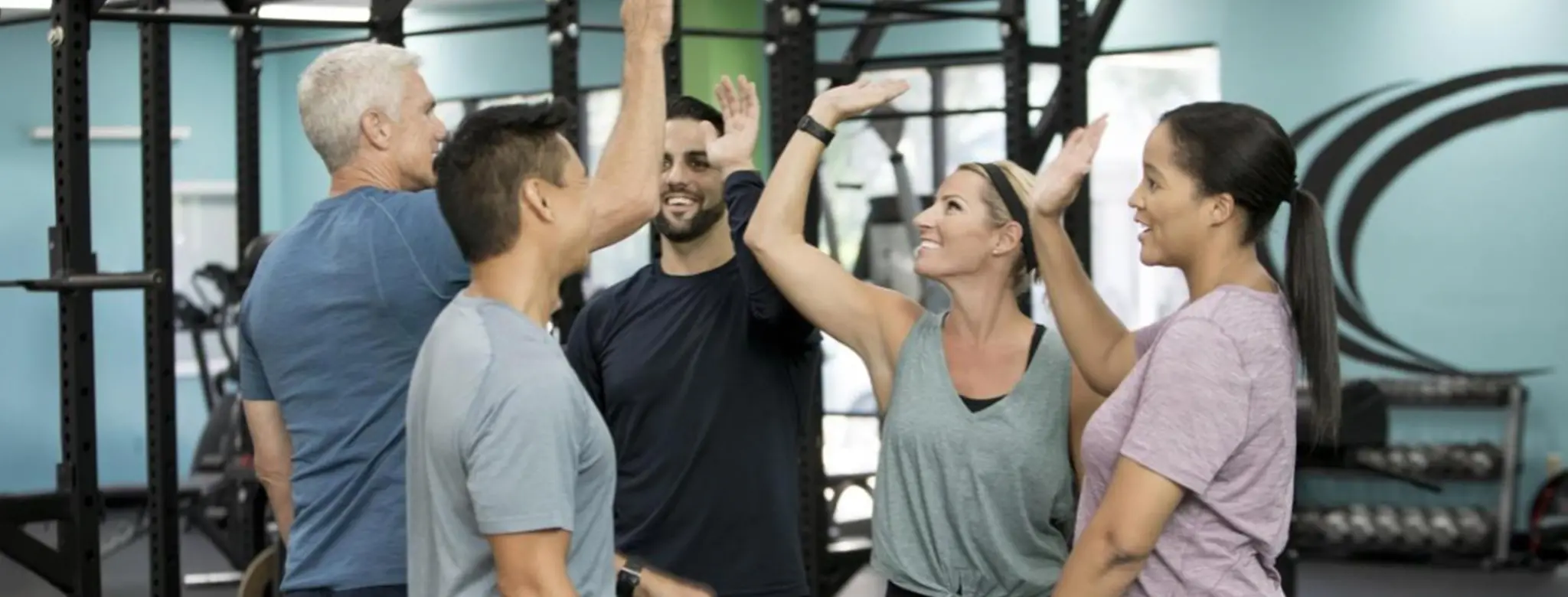 group of people high fiving in the gym