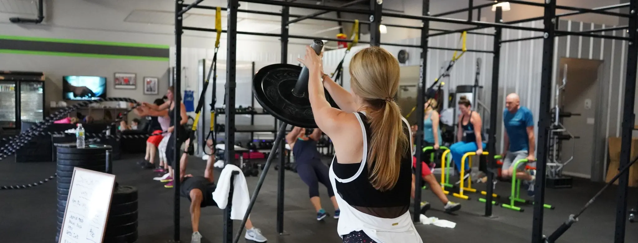 Woman exercising with heavy weights  in a high-intensity fitness studio