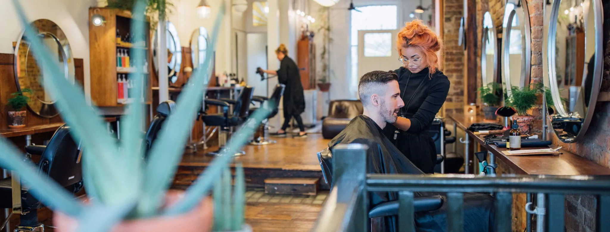 Stylist styling male client's hair