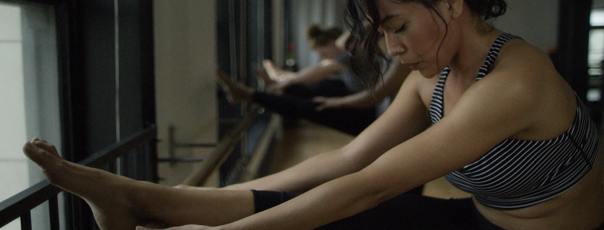 woman in striped sports attire doing barre
