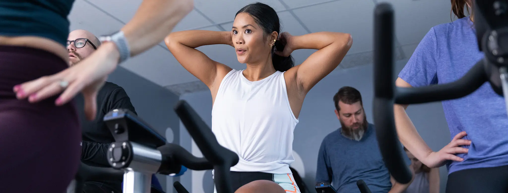 woman in an indoor cycling class working out with group
