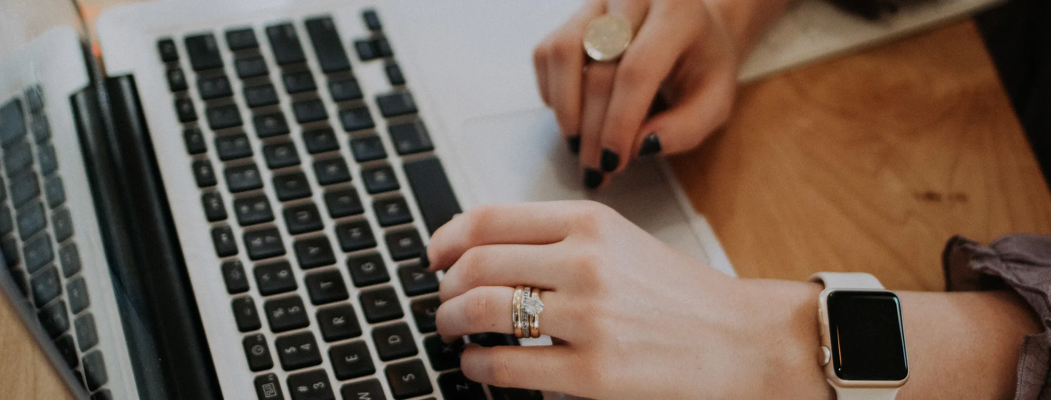 woman typing on laptop with apple watch