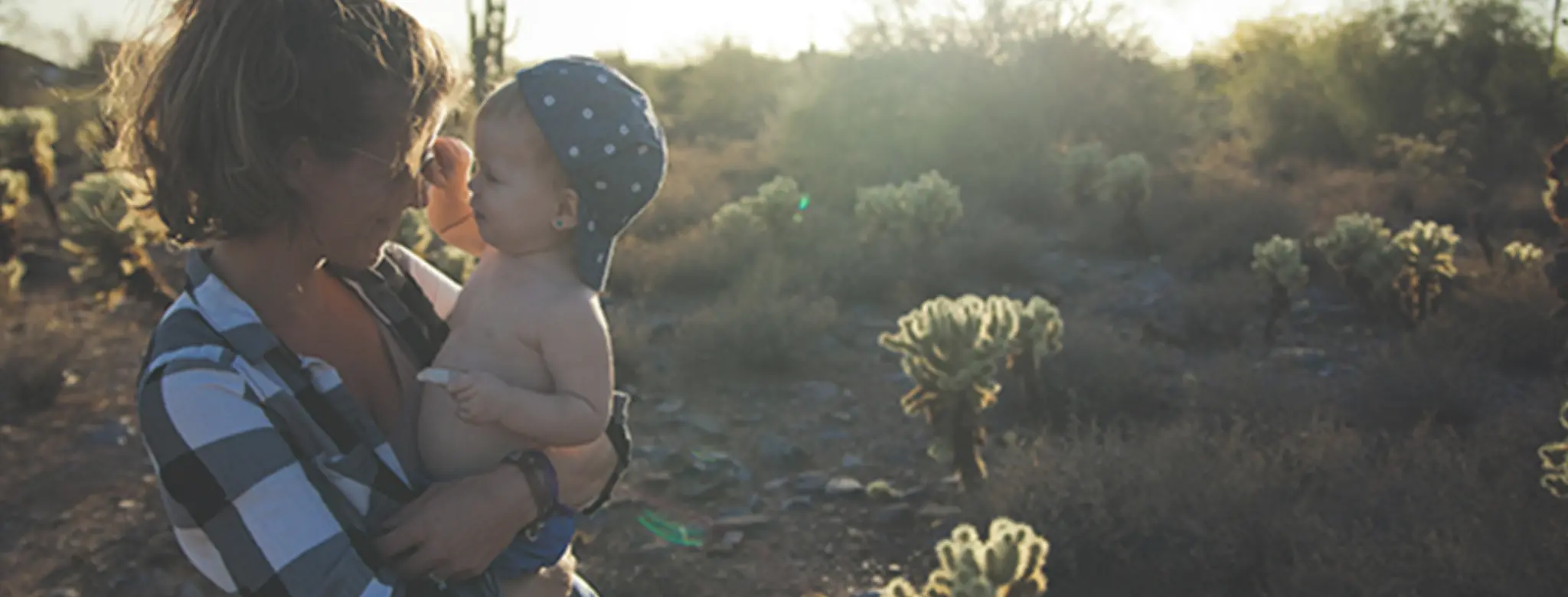 mother holding her baby son in desert