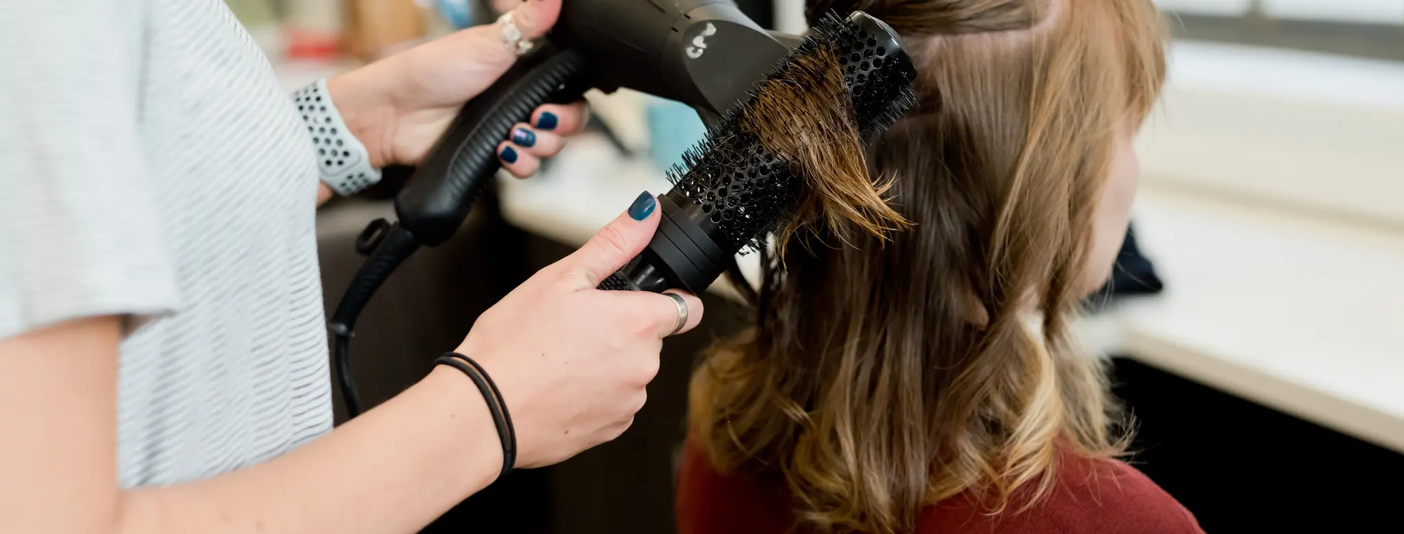woman getting hair blown out at salon
