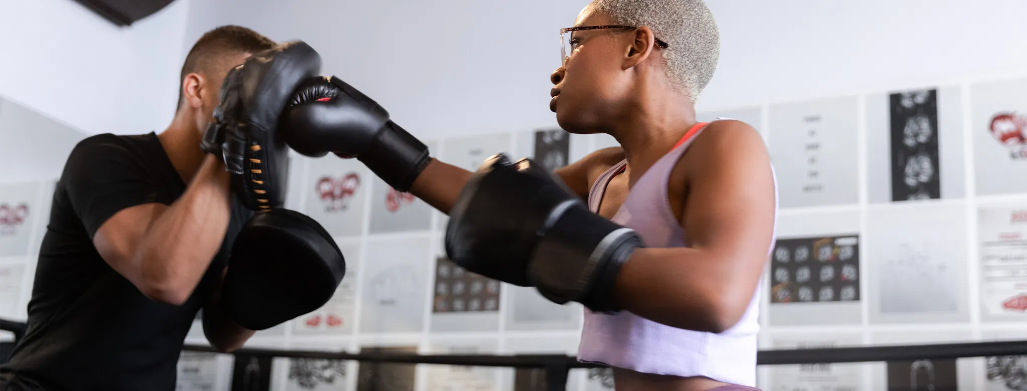man and woman boxing in gym