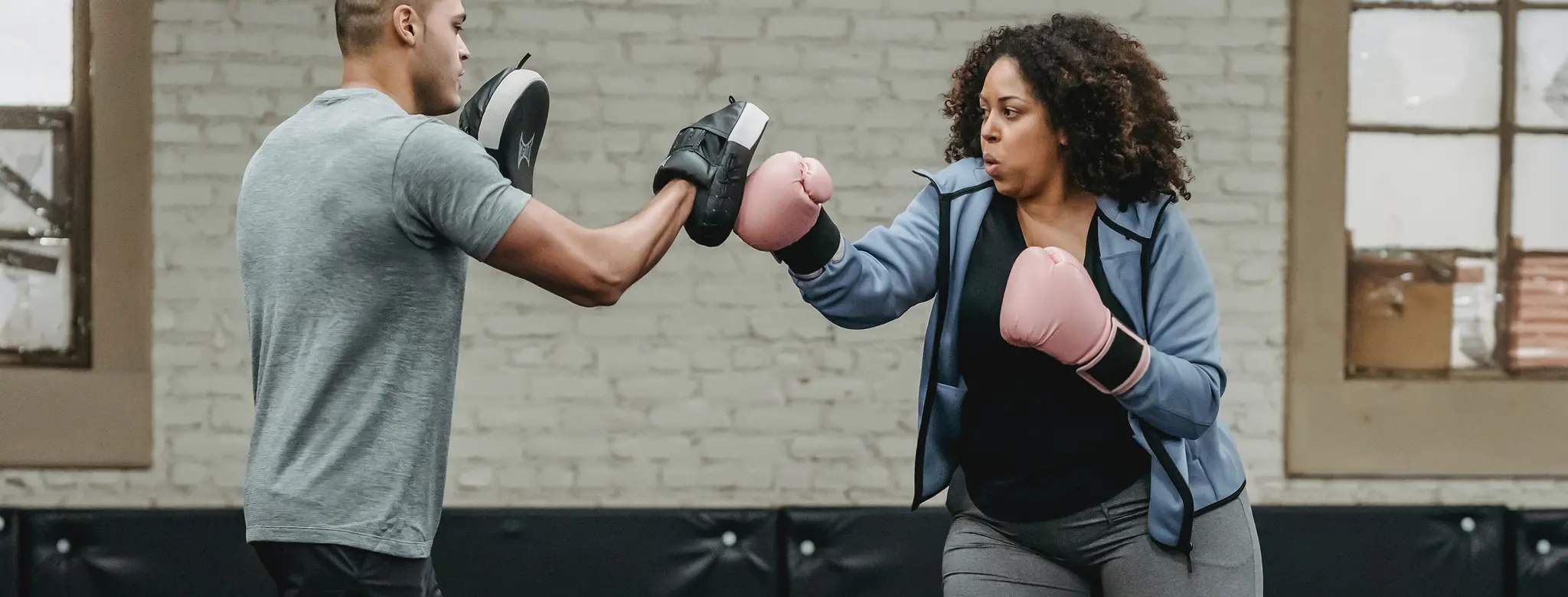 man and woman boxing in gym