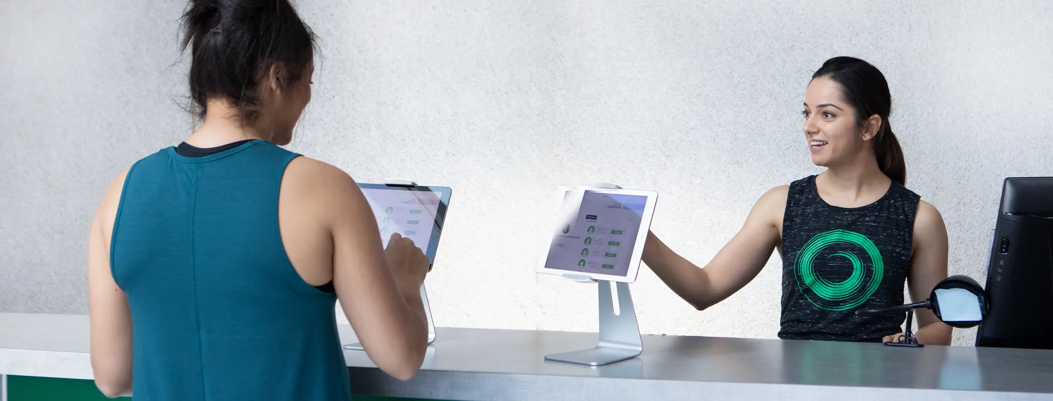 Women checks into fitness studio using iPad.